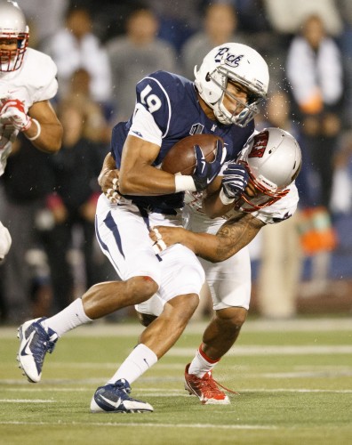 UNR's Wyatt Demps (19) gets tackled by UNLV's Peni Vea (42)